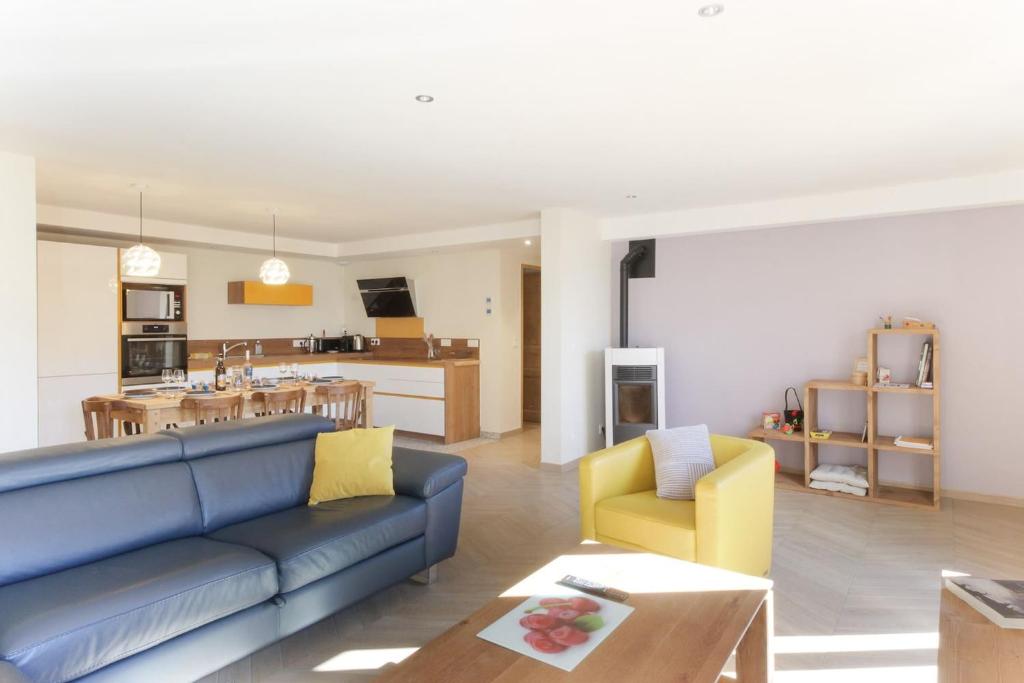 a living room with a blue couch and a kitchen at L'Abeille - Renovated - 4 bedroom - 8 person-110sqm - Views! in Les Houches