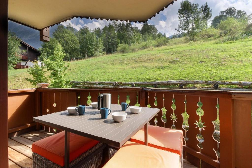 a table on a balcony with a view of a hill at Le Grand Tetras - Beside Lake Chavants, TMB staring point & Hikes in Les Houches