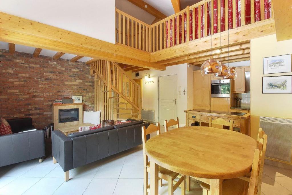 une cuisine et une salle à manger avec une table et des chaises en bois dans l'établissement Le Quatre - 75m2 Charmant Duplex - Central - 8-10 pax 3ch, à Saint-Gervais-les-Bains