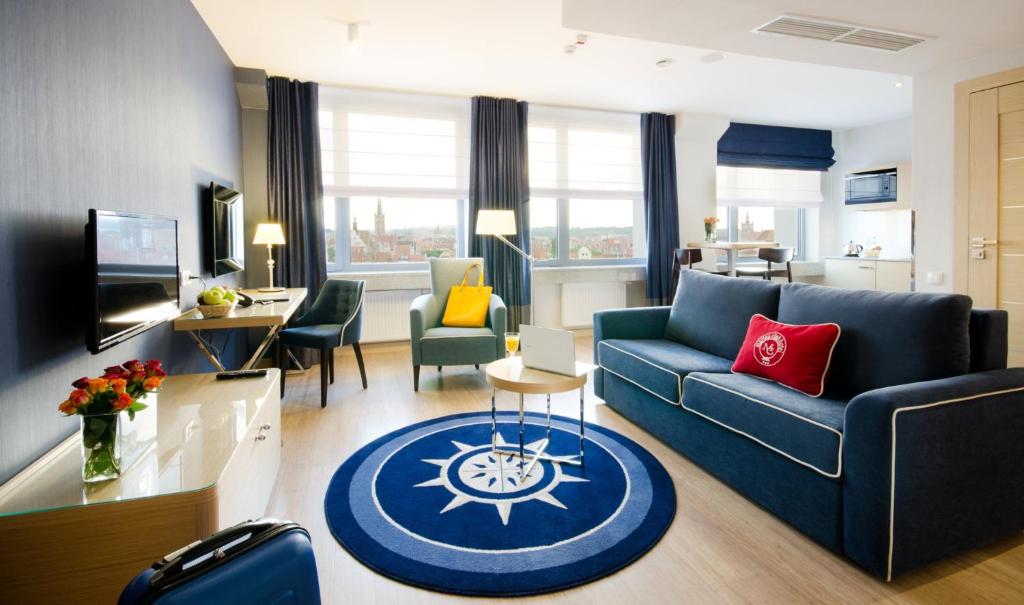 a living room with a blue couch and a table at Hotel Marina Club Old Town View in Gdańsk