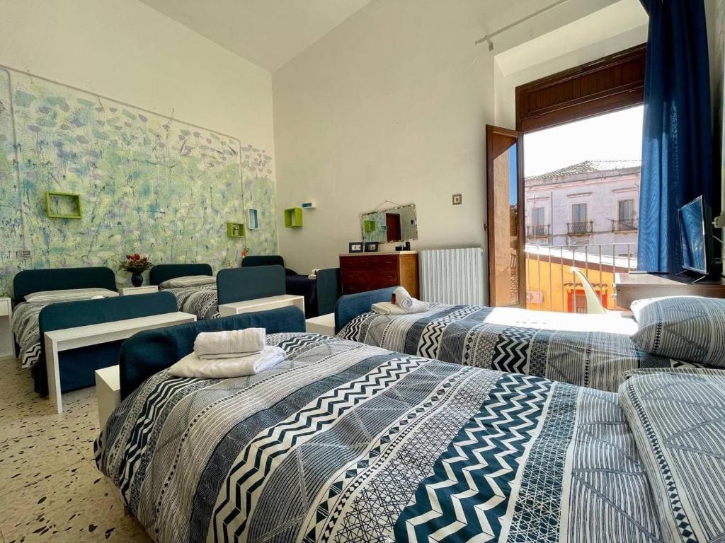 um quarto com quatro camas e um sofá em Casa di Chiara em Crotone
