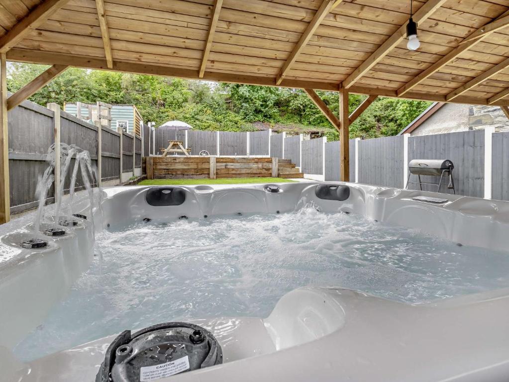a jacuzzi tub in a backyard with a wooden roof at 2 bed in Tregaron 89010 in Tregaron