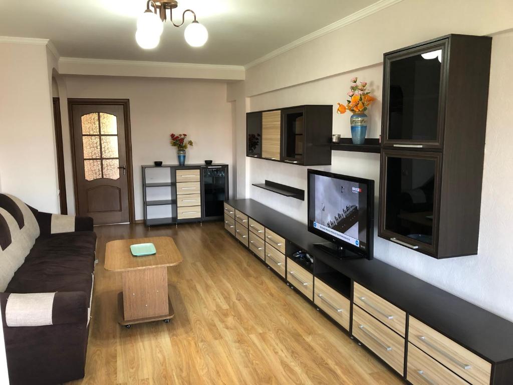 uma sala de estar com um sofá e uma televisão de ecrã plano em Elegant 3-room apartment near iMall: Kievskaja Street em Bishkek