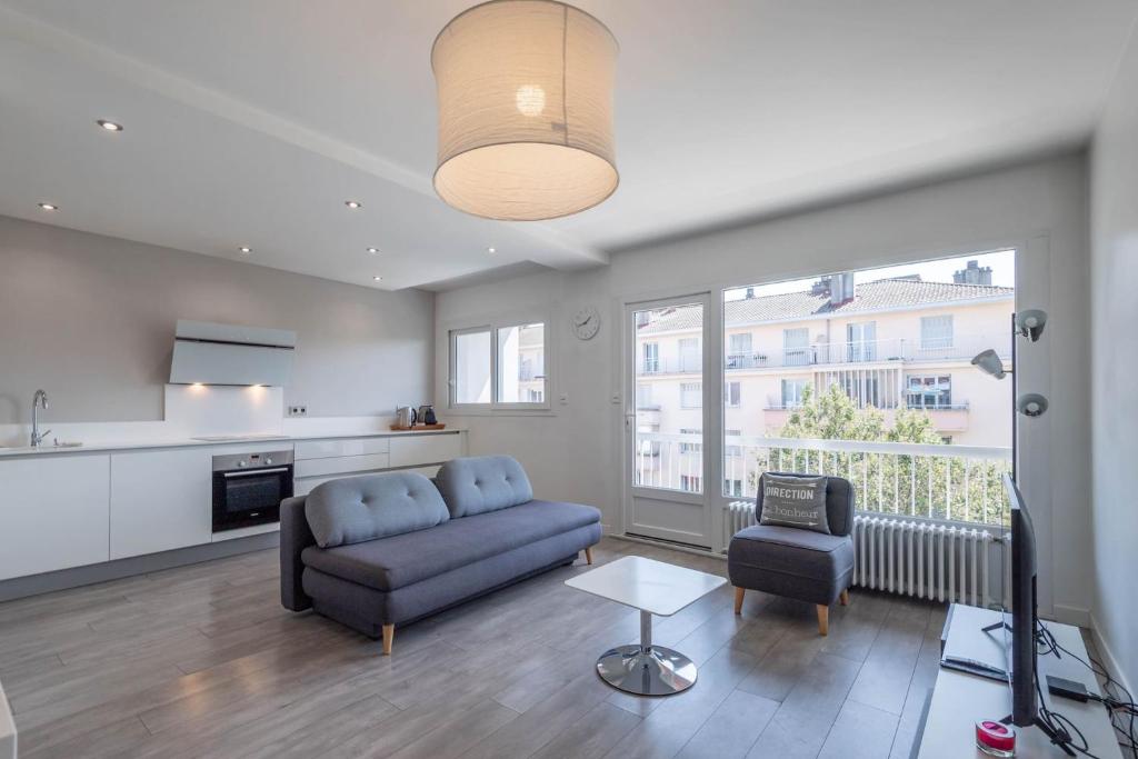 un salon avec un canapé bleu et une table dans l'établissement SmartStay Le Thiou - Annecy centre, à Annecy