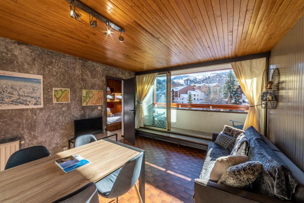 a living room with a couch and a table at DIFY Grand Soleil - Courchevel 1650 in Courchevel