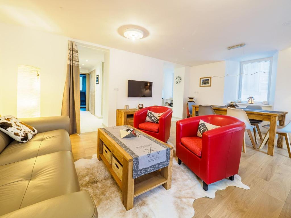 een woonkamer met 2 rode stoelen en een tafel bij DIFY Clos des Roches - Chamonix in Chamonix-Mont-Blanc