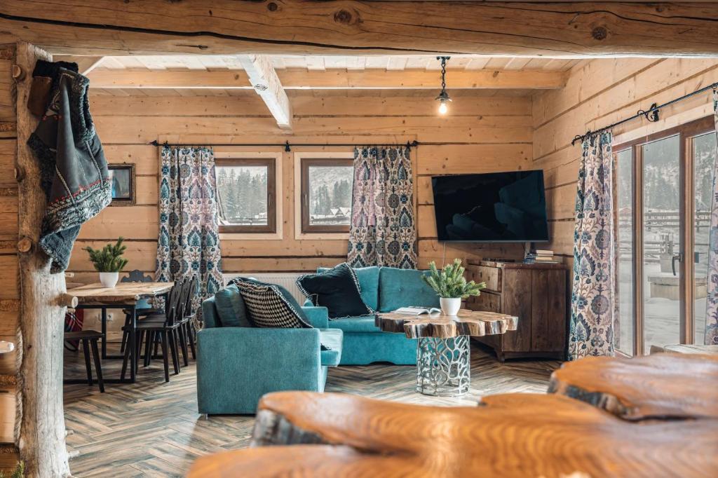 Domek Między Dolinami في فيتوف: غرفة معيشة مع أريكة زرقاء وتلفزيون