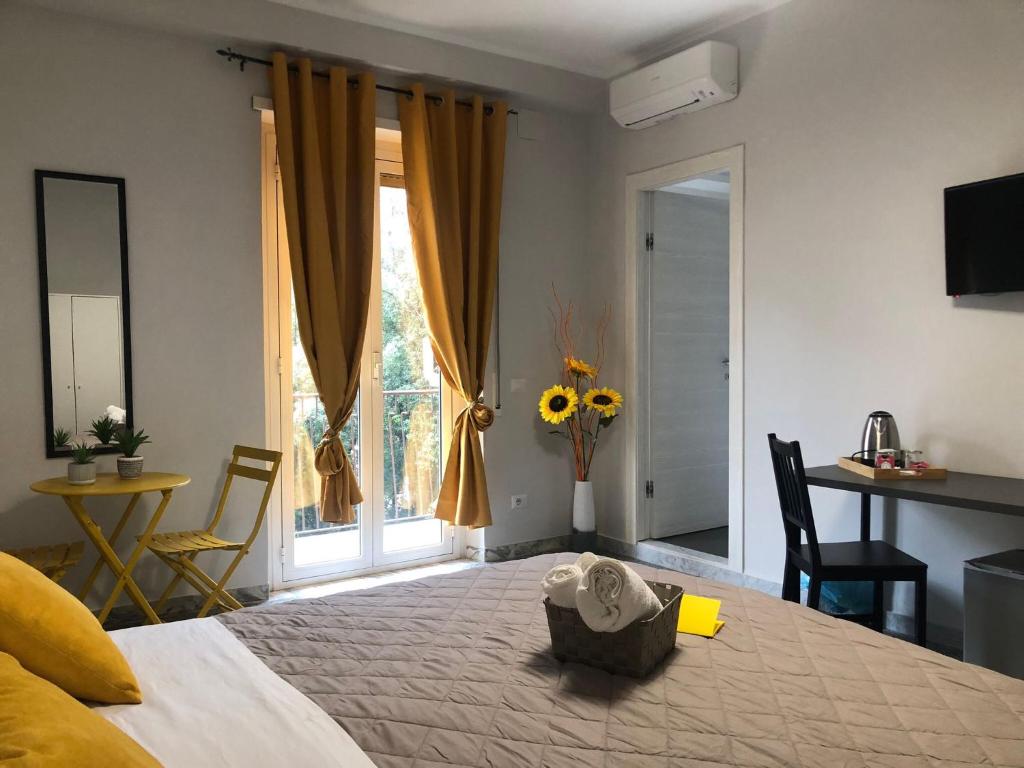 a bedroom with a bed and a table and a window at Flower Inn Marconi Roma in Rome