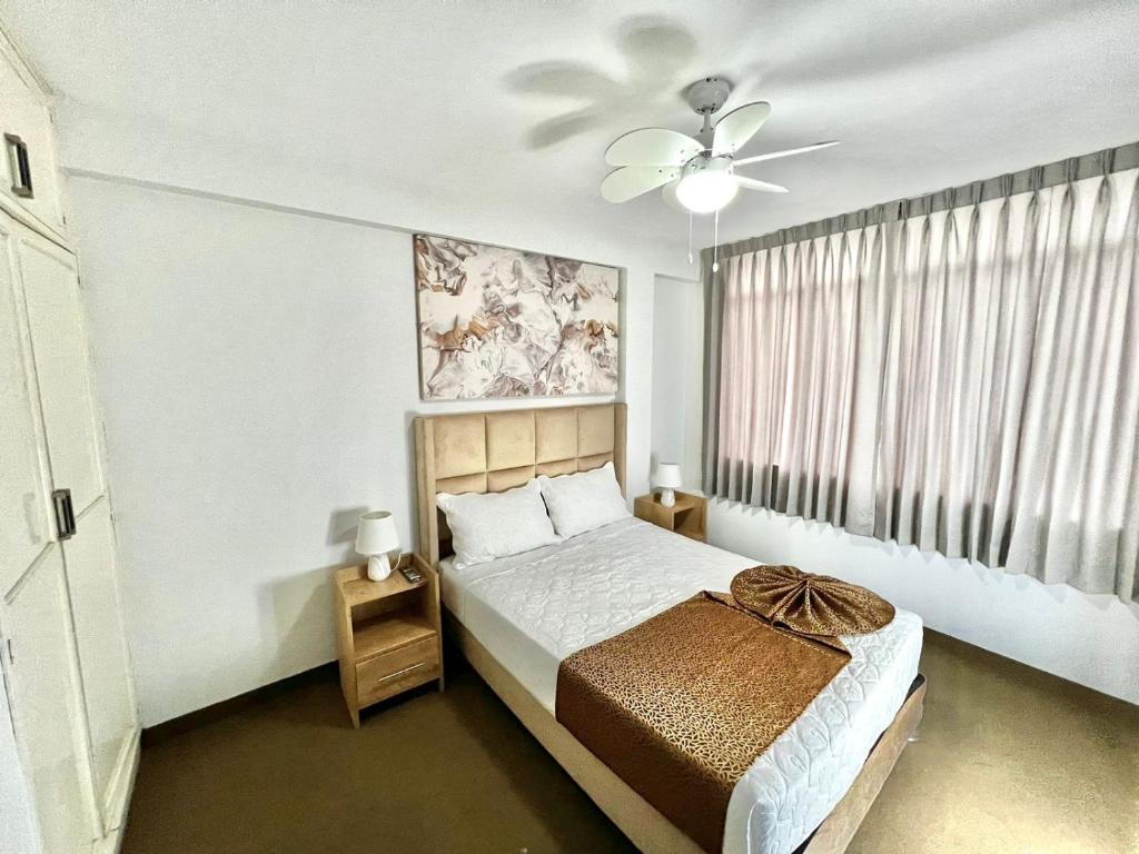 a bedroom with a bed and a ceiling fan at Costa Bella in Ilo