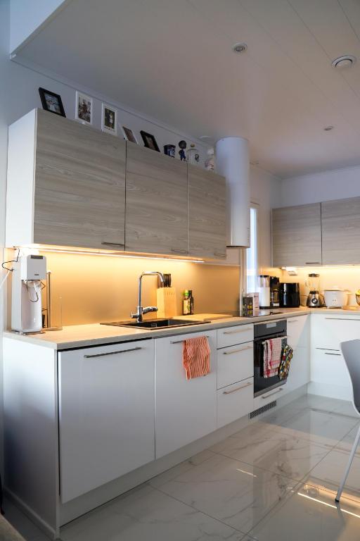 a kitchen with white cabinets and a sink at Modern semi-detached house with wonderful location! in Rovaniemi