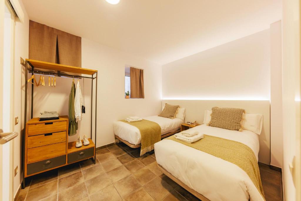 ein kleines Schlafzimmer mit 2 Betten und einer Kommode in der Unterkunft Bravissimo Mercadal, one-bedroom plus sofa bed in Girona