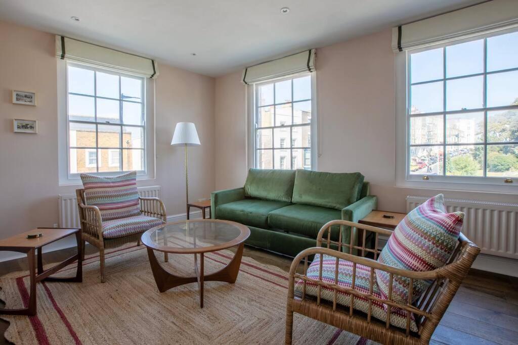 a living room with a green couch and chairs at Palm Heights - top floor luxury flat in Margate