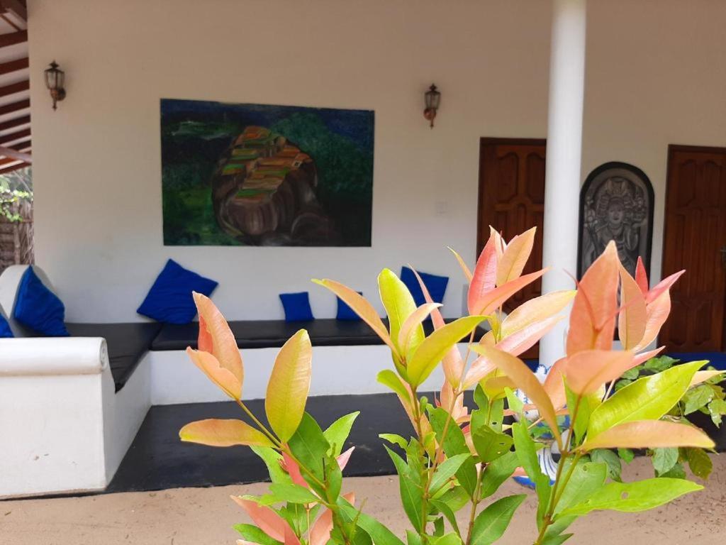 una sala de estar con sofá y una pintura en la pared en PEARL STAR BEACH RESORT, en Alankuda