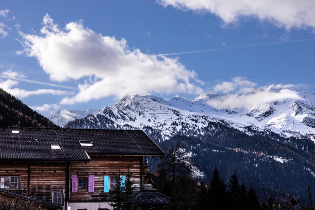a house with a view of a snowy mountain at Almgasthof Windischgrätz in Bad Gastein