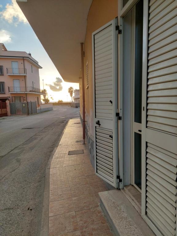 uma rua vazia ao lado de um edifício com uma porta em b&b Sirianni em SantʼEufemia Lamezia