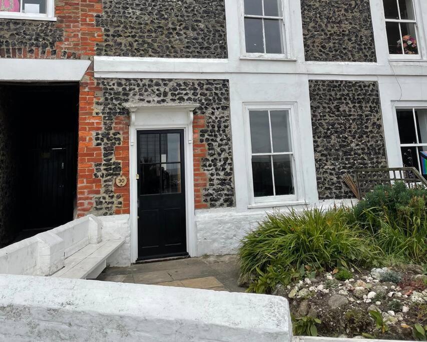 a building with a black door and a brick building at Turner Cottage - 3 bed with a View of the Harbour in Margate