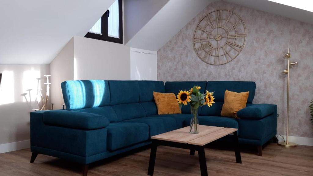 ein blaues Sofa im Wohnzimmer mit einem Tisch in der Unterkunft Había Una Vez in El Espinar