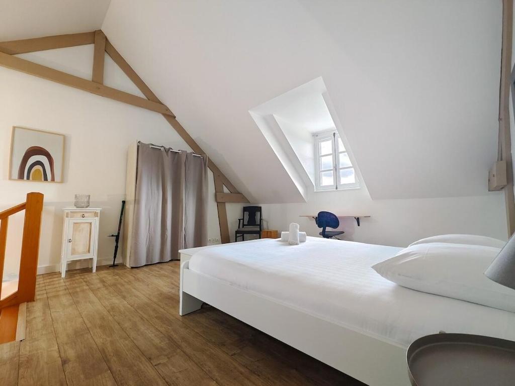 een slaapkamer met een groot wit bed en een raam bij Charmante petite maison en plein centre ville in Caen