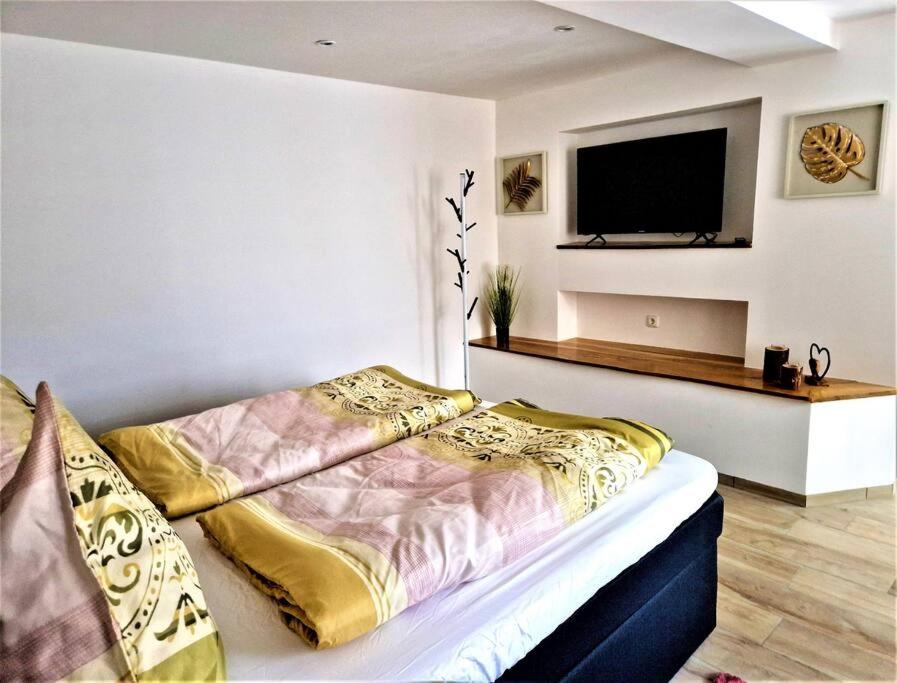 1 dormitorio con 1 cama y TV de pantalla plana en charmantes Landhaus "Wildrose", kurz vor Halle, 4 Schlafzimmer, en Petersberg