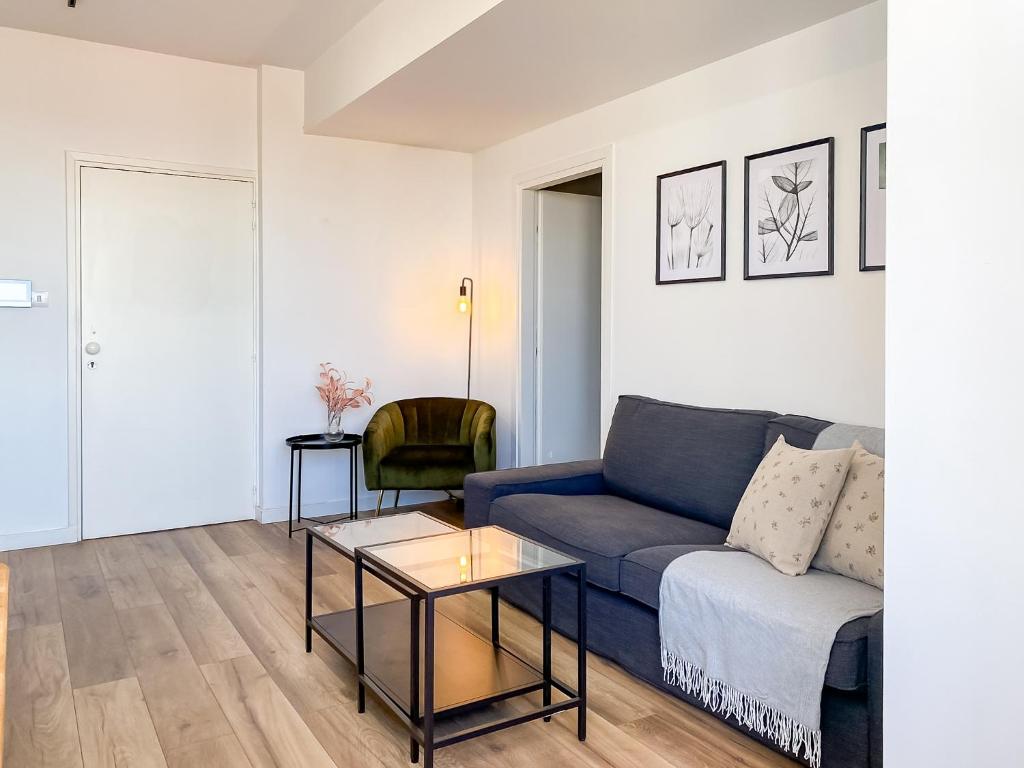 een woonkamer met een blauwe bank en een tafel bij Phaedrus Living: Ourania City Heights Flat in Limassol