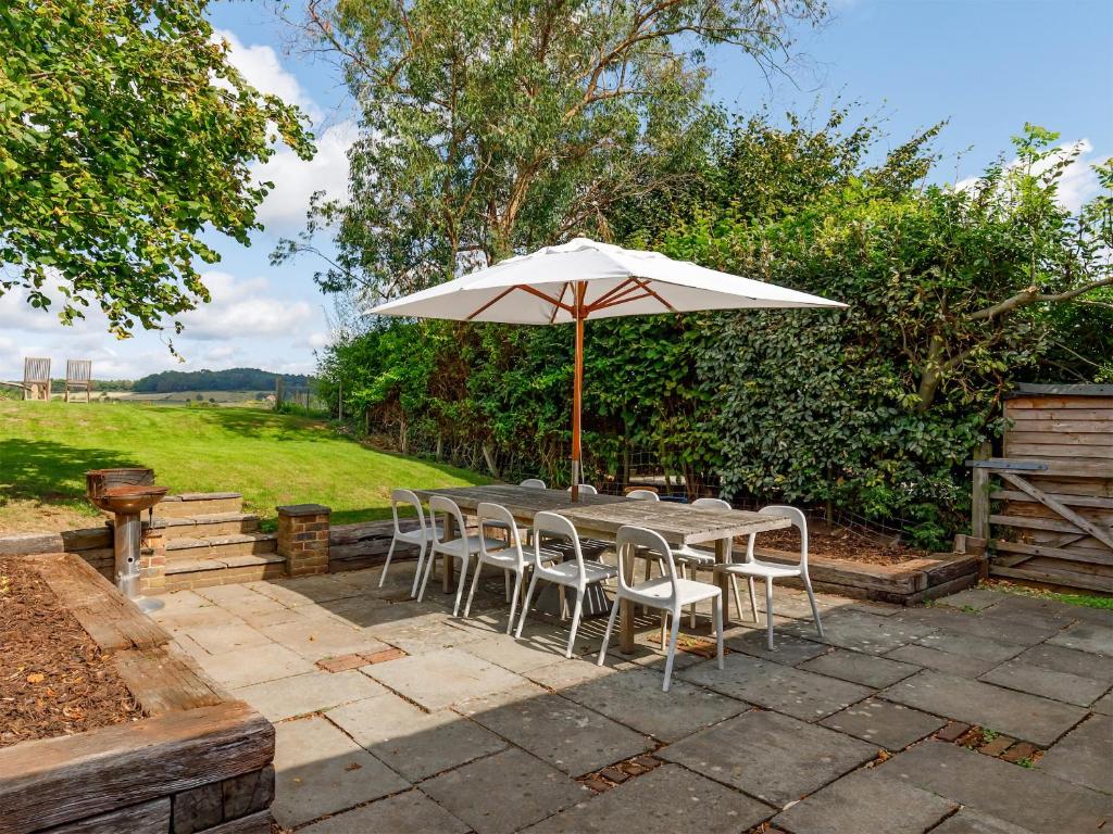 - une table et des chaises avec un parasol sur la terrasse dans l'établissement The Courtyard, à Pulborough