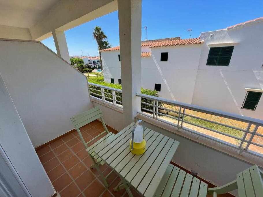 卡拉恩布拉內斯的住宿－Macarella Apatamento con piscina，阳台设有长凳和圆锥形锥形