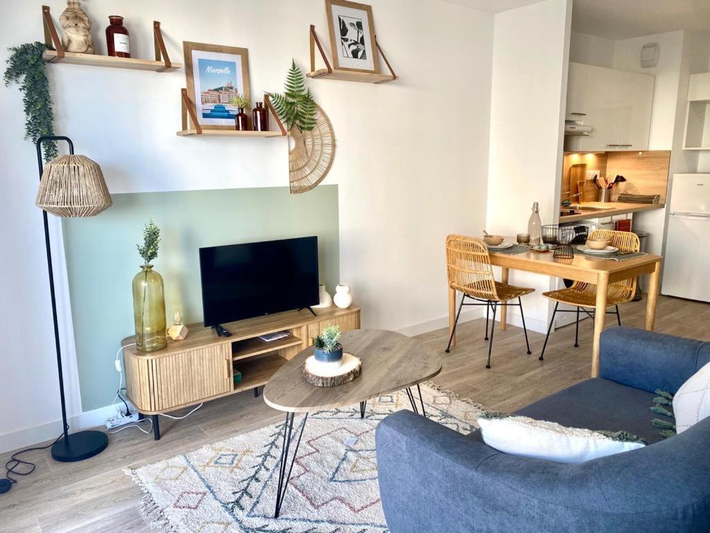 un salon avec une télévision et une table dans l'établissement Résidence de Marseille Valmante, à Marseille