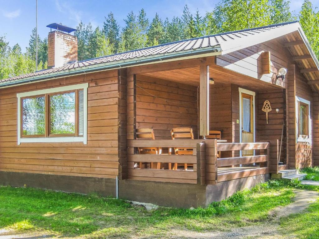 een houten hut met een veranda en een hek bij Holiday Home Iltarusko by Interhome in Savonranta