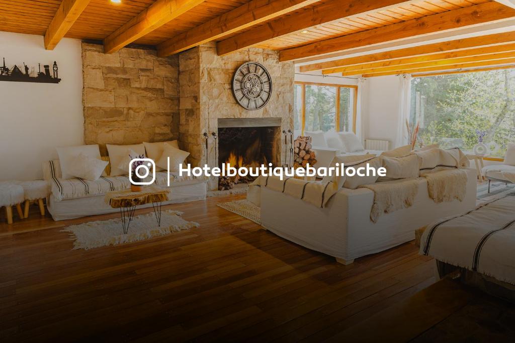 Hosteria Boutique Bariloche في سان كارلوس دي باريلوتشي: غرفة معيشة مع أريكة ومدفأة