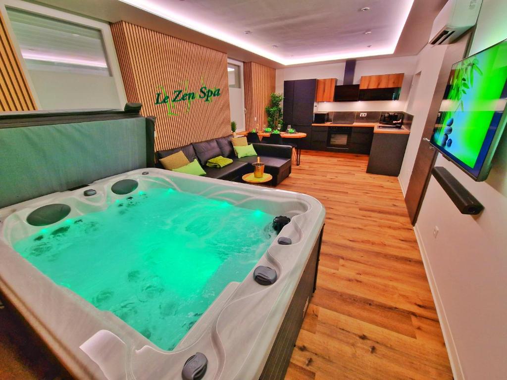 a room with a bath tub in a living room at -Le Zen Spa+Jacuzzi+Parking+Clim in Colmar