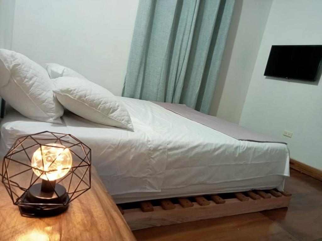 a bedroom with a bed with a lamp on a table at Cómodo apartamento in Jericó