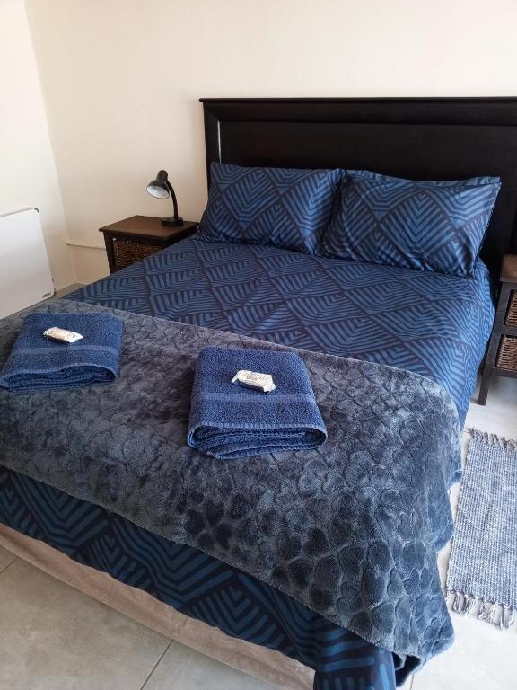 ein Schlafzimmer mit einem Bett mit blauen Handtüchern darauf in der Unterkunft Annies Overnight in Vanderbijlpark