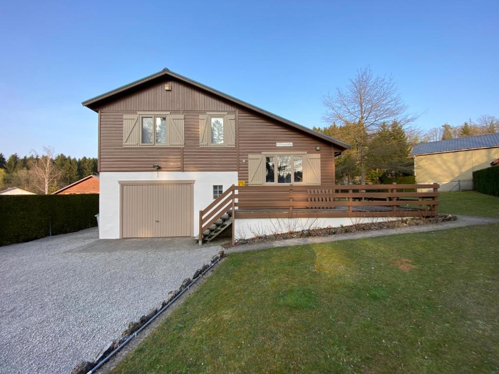 een groot huis met een garage en een oprit bij Chalet 't Vraagteken in Durbuy