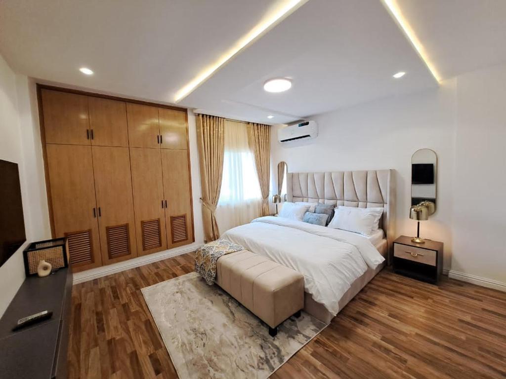 Un dormitorio grande con una cama grande y suelos de madera. en Luxurious comfort in the heart of Ikoyi Lagos, en Lagos