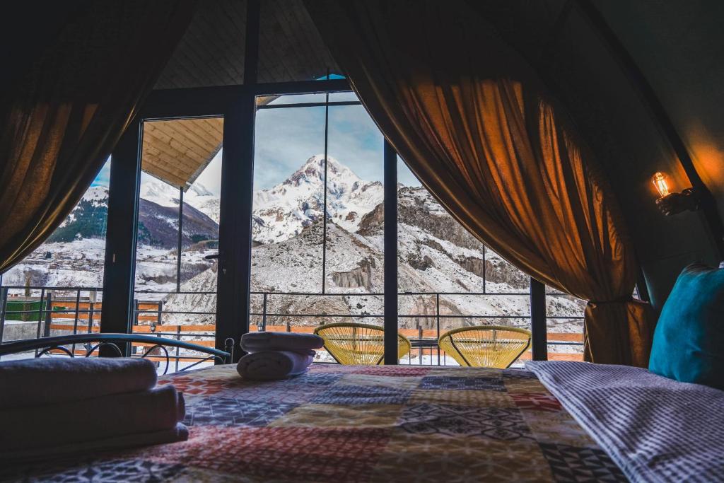 a bedroom with a view of a snow covered mountain at Kuro Glamping in Kazbegi