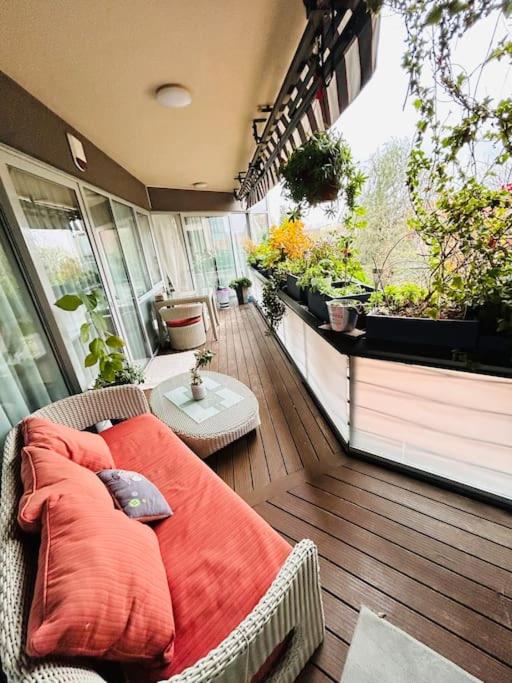 Un balcón con una cama en una terraza con plantas. en Pure Luxury Residence, en Timisoara