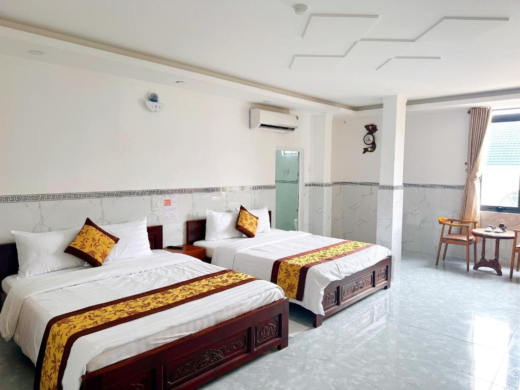 Habitación de hotel con 2 camas y mesa en Cao Lanh Hotel, en Ấp Mỹ Ðông