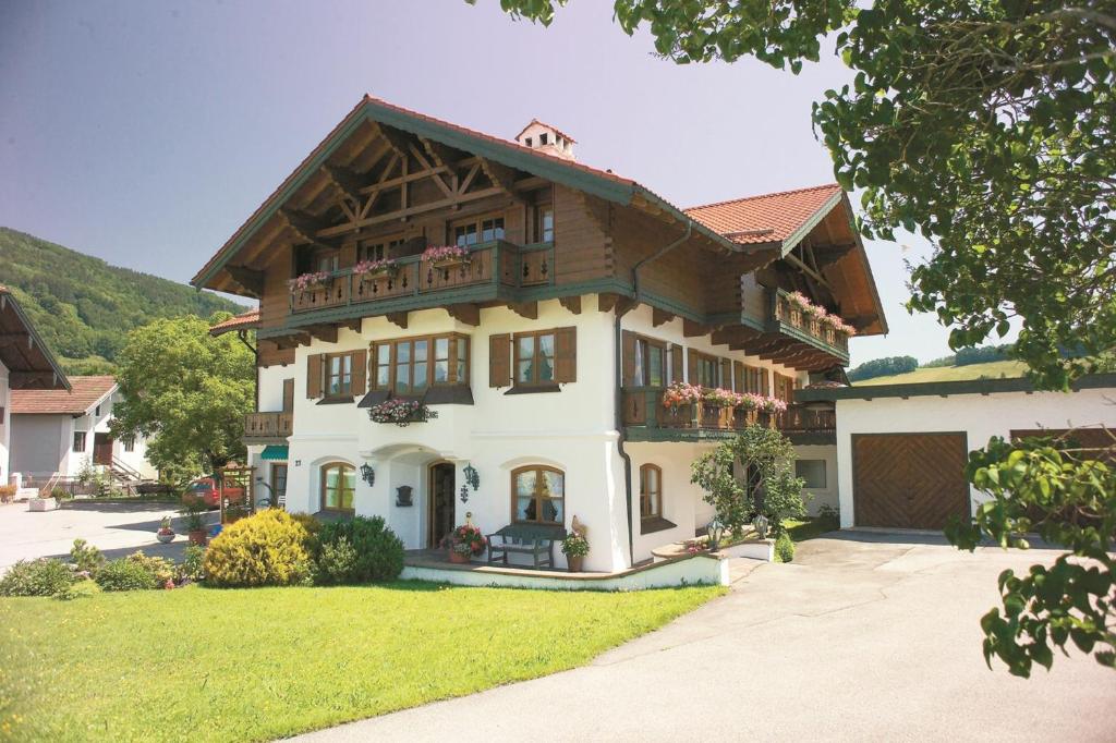 a large white house with a wooden roof at Ferienwohnungen Beim Zellerbäck in Ruhpolding