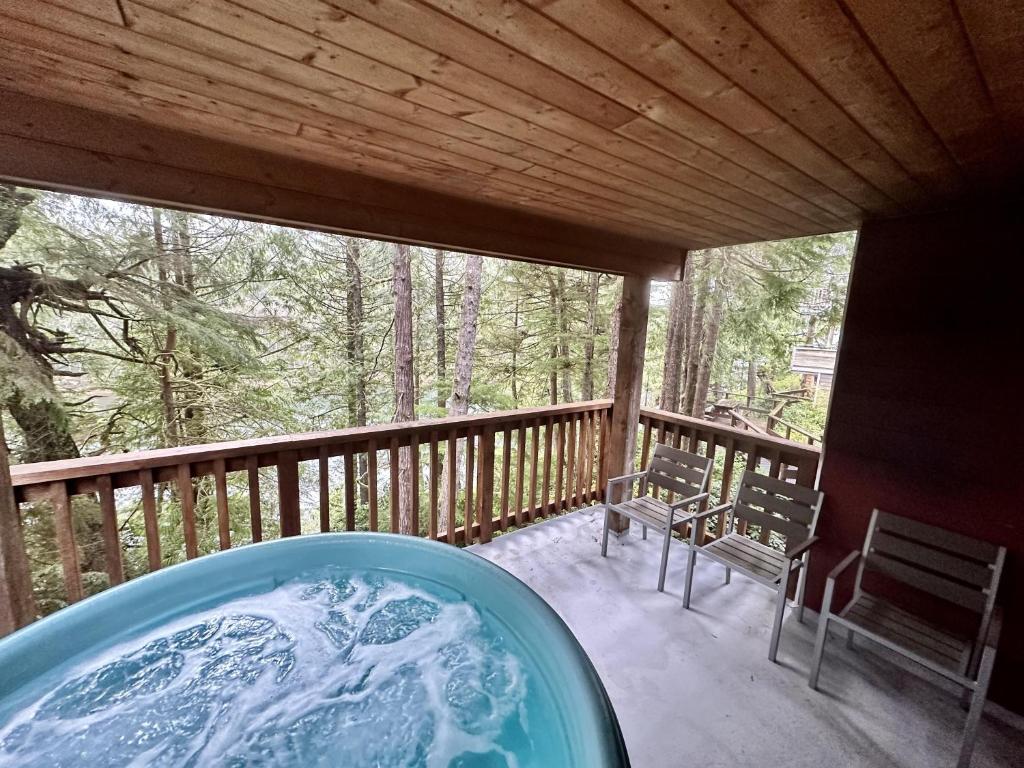 einen Whirlpool auf dem Deck einer Hütte in der Unterkunft Cozy 2 Bedroom Waterfront Cottage With Hot Tub! in Ucluelet