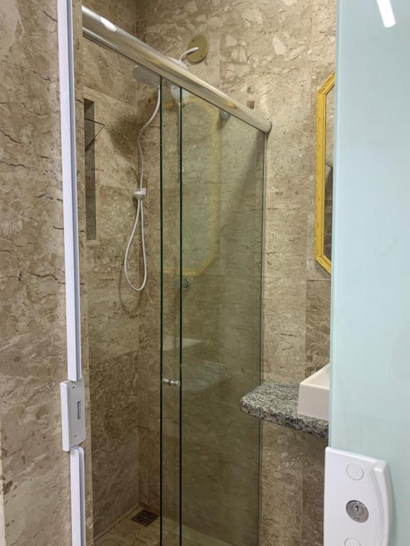 a shower with a glass door in a bathroom at Pousada Olívia in São Pedro da Aldeia