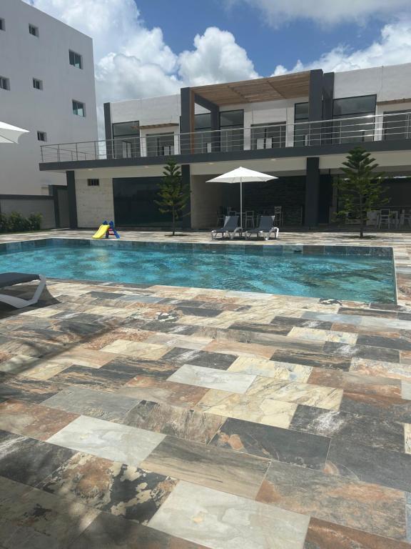 a swimming pool in front of a building at Acogedor Apartamento Familiar con piscina. in Boca Chica
