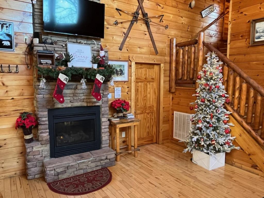 ein Wohnzimmer mit einem Kamin und einem Weihnachtsbaum in der Unterkunft Makin Memories, 2 Bedrooms, Sleeps 6, Arcade, Pool Table, Jetted Tub in Sevierville