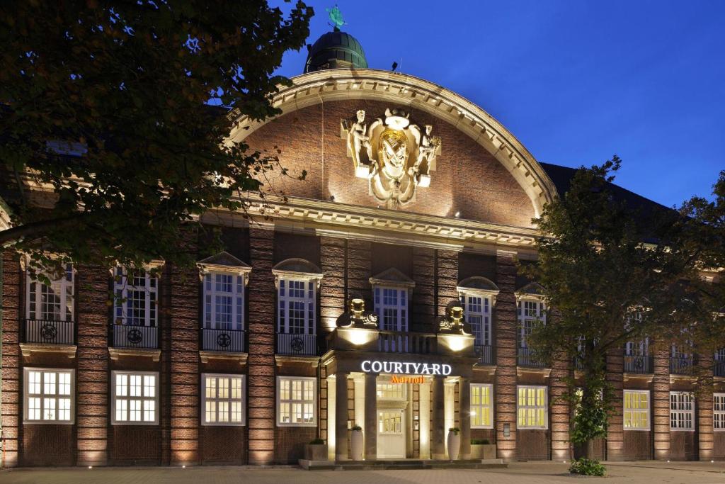 ein Gebäude mit einer Uhr auf der Vorderseite in der Unterkunft Courtyard by Marriott Bremen in Bremen