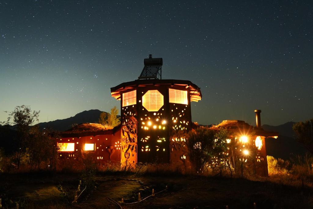 Un bâtiment éclairé avec des lumières allumées la nuit dans l'établissement Swiss Eco Lodge La Linda Loma - Olmué, à Olmué