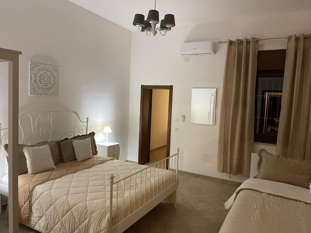 Medea Home في Carosino: غرفة نوم بيضاء بها سرير ونافذة