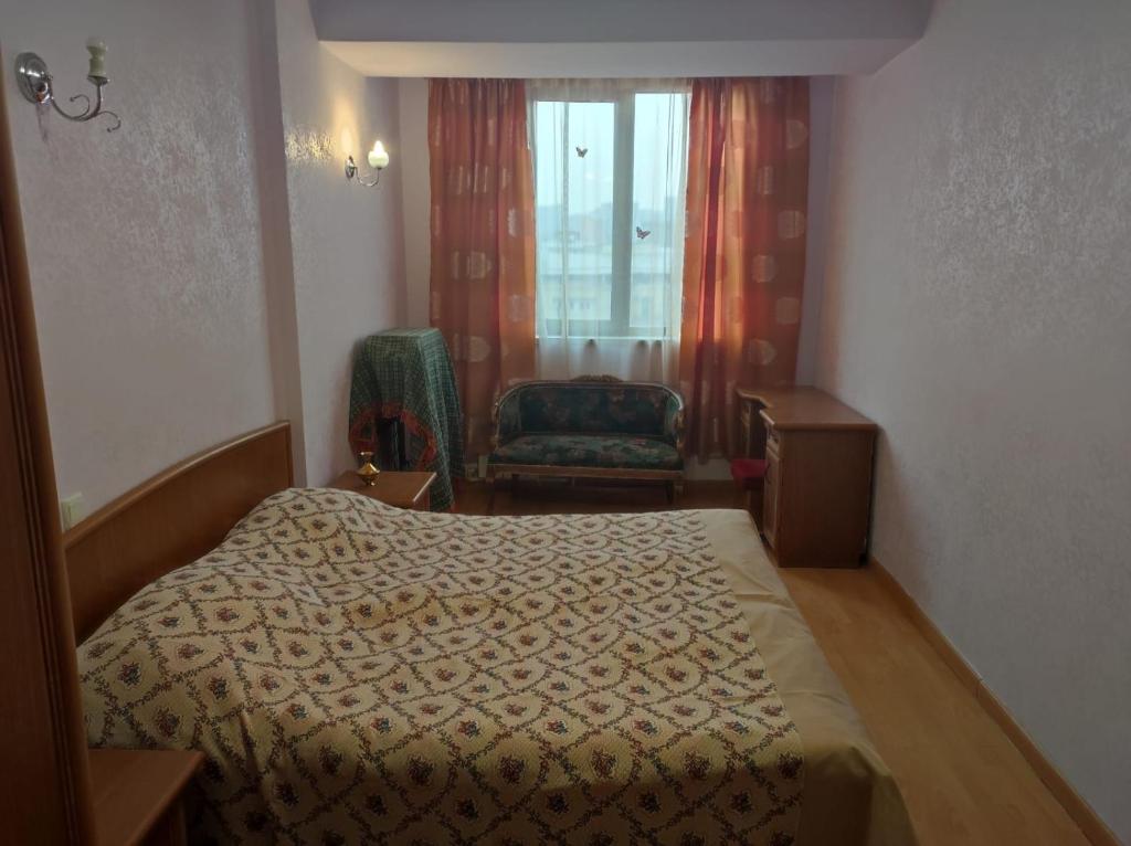 1 dormitorio con 1 cama, 1 silla y 1 ventana en Byuzand 7 en Ereván
