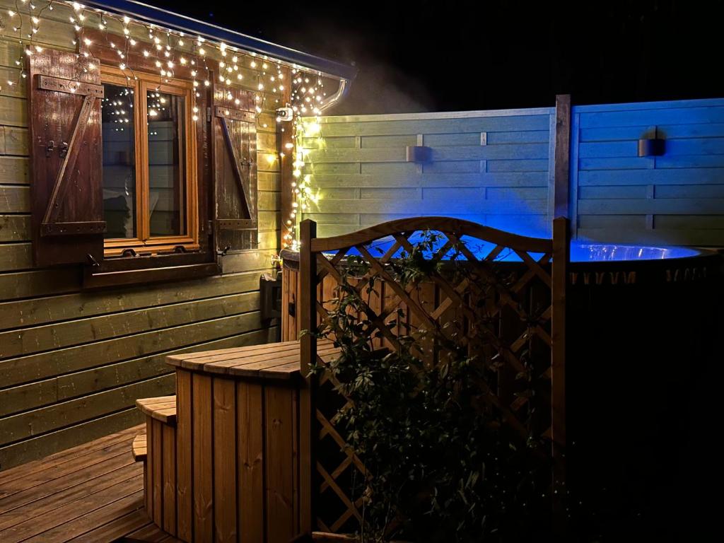 a house with christmas lights on the side of it at Le chalet du lys avec bain scandinave Insolys in Gouvieux
