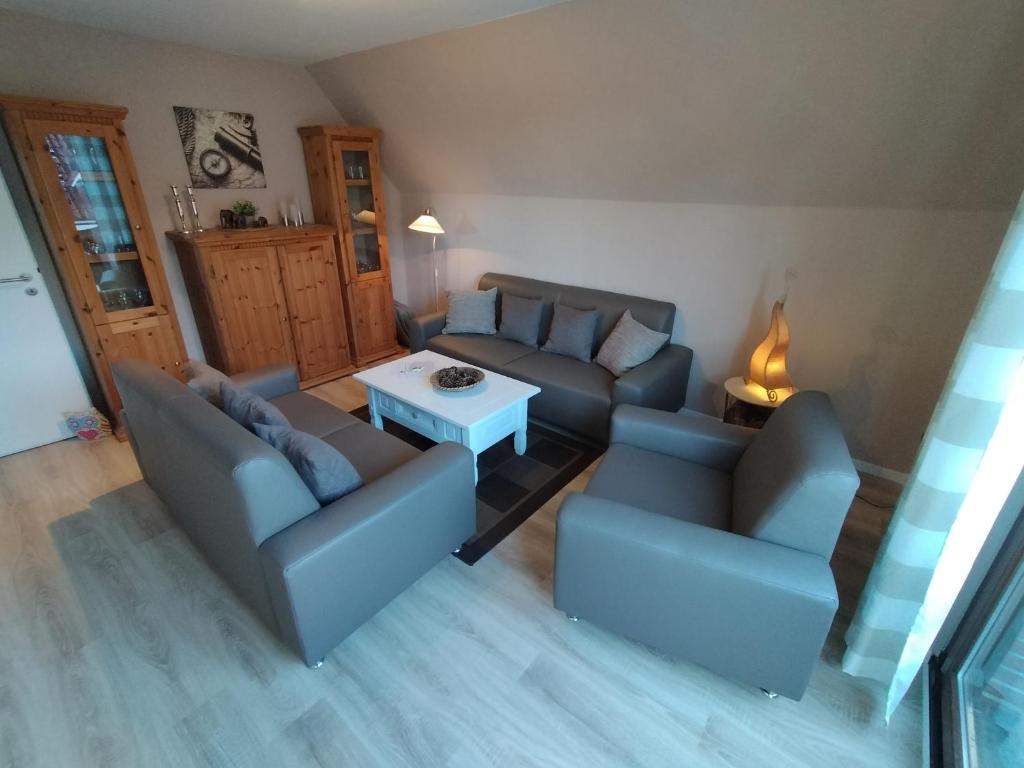 a living room with two couches and a table at Ferienwohnung Am Ems-Seitenkanal 65353 in Moormerland
