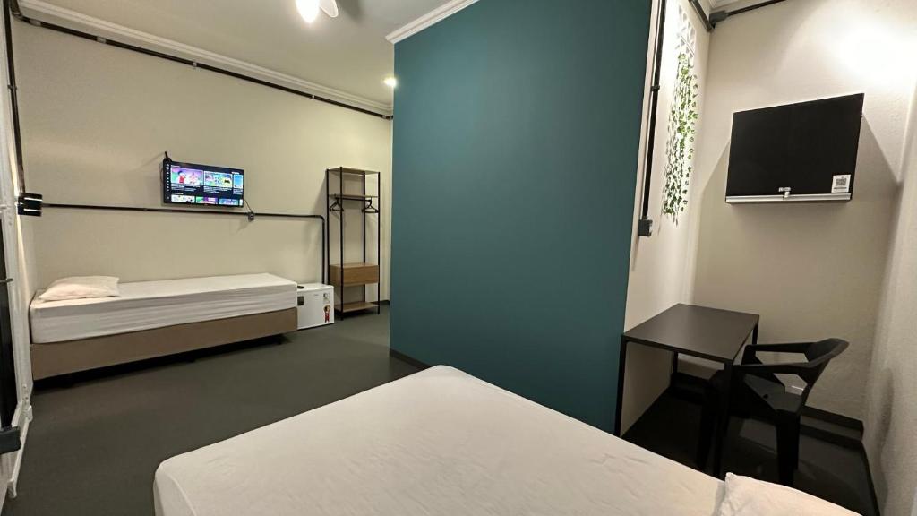 ein Krankenhauszimmer mit einem Bett und einem TV in der Unterkunft Suíte nº 11 - Praia das Pitangueiras in Guarujá