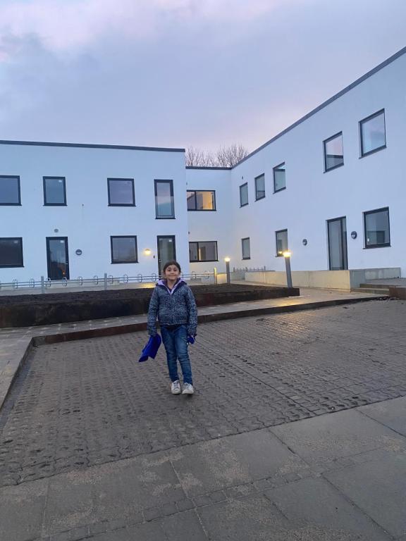 una joven parada frente a un edificio en Especial fin de semana, en Rødovre